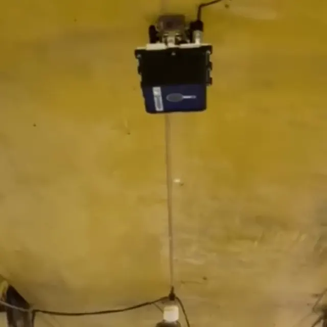 Câmera Kindra presa no teto do corredor de uma granja de suínos